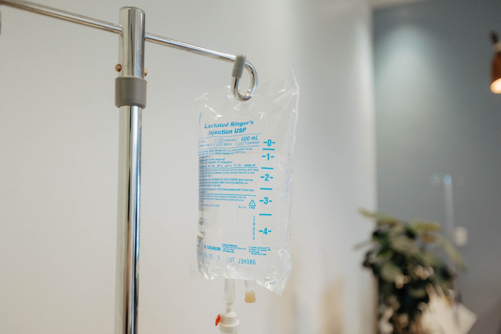 An IV bag hanging on a stand in a bright treatment room